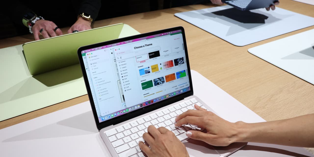 The new 12-inch plastic MacBook Neo rendering 4K video while displaying high chassis surface temperatures and Geekbench scores.